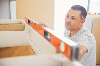 Contractor installing modified cabinets
