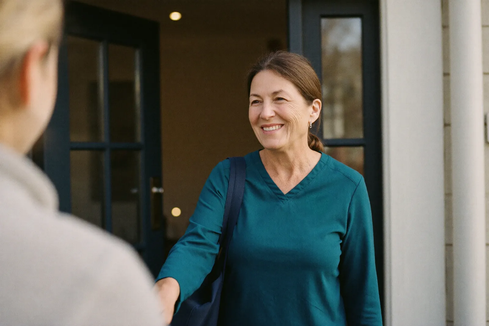 A therapist greeting a resident at her front door