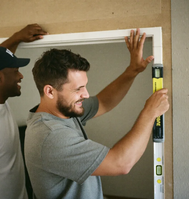 Two contractors fitting a widened door frame